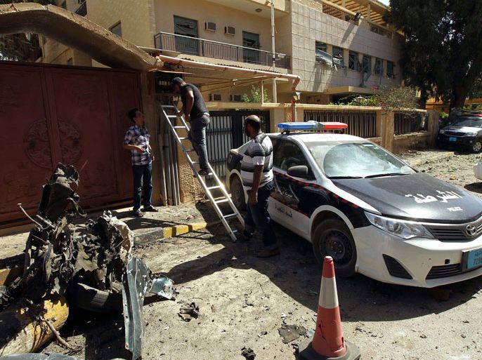 BENGHAZI, -, LIBYA : Libyan police and bystanders gather at the scene of car bomb explosion outside the Swedish consulate in the eastern Libyan city of Benghazi on October 11, 2013 which seriously damaged the building but caused no casualties. The Swedish mission is one of the few remaining diplomatic offices remaining in Benghazi, which was the cradle of uprising and frequently sees attacks on security personnel and institutions. AFP PHOTO/ABDULLAH DOMA