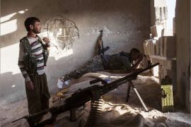 Armed fighters of the Committees for the Protection of the Kurdish People (YPG) hold a position in a building on October 16, 2013 in the Syrian town of Ras al-Ain, close to the Turkish border. At least 41 fighters have been killed in violent clashes pitting Kurds against jihadists and Islamist rebels in northeastern Syria, a monitoring group said on October 16, 2013. AFP PHOTO STR
