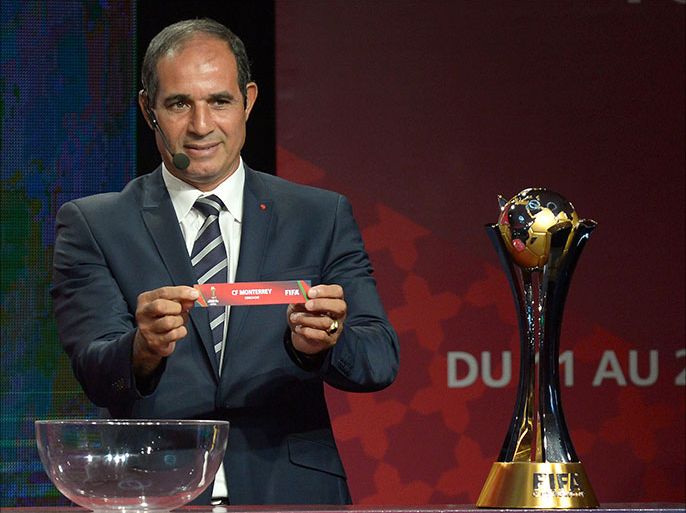 Badou Zaki, former Moroccan goalkeeper and coach, shows the name of Monterrey during the draw for the 2013 Club World Cup in Marrakech on October 9, 2013. Morocco will host this year's tournament with European champions Bayern Munich and Copa Libertadores winners Atletico Mineiro. AFP PHOTO /FADEL SENNA