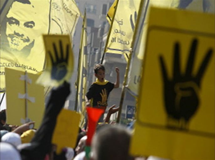 Supporters of Egyptian ousted president Mohamed Morsi hold flags and posters bearing the Rabaa sign as they demonstrate against the military in Cairo's eastern Nasr City district on October 11, 2013. Around 2,000 Islamists rallied in Cairo after organisers backtracked from marching on Tahrir Square, avoiding a repeat of last week's clashes with police that killed dozens of people. The "Rabaa", which means four in Arabic, refers to those killed in the crackdown on the Rabaa