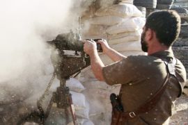 A Free Syrian Army fighter fires towards the village of Aziza, which is under the control of forces loyal to Syria's President Bashar al-Assad, in the southern countryside of Aleppo October 5, 2013.