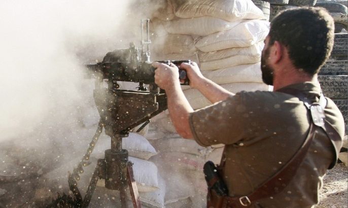 A Free Syrian Army fighter fires towards the village of Aziza, which is under the control of forces loyal to Syria's President Bashar al-Assad, in the southern countryside of Aleppo October 5, 2013.