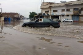 IRAQ : An Iraqi man drives his car through a flooded street in Baghdad on November 20, 2013, as flash floods sparked by torrential rain swept throught region. AFP PHOTO/SABAH ARAR