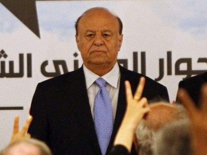 Yemen's President Abd-Rabbu Mansour Hadi stands as the national anthem is played during the third plenary meeting of a national dialogue conference in Sanaa October 8, 2013.
