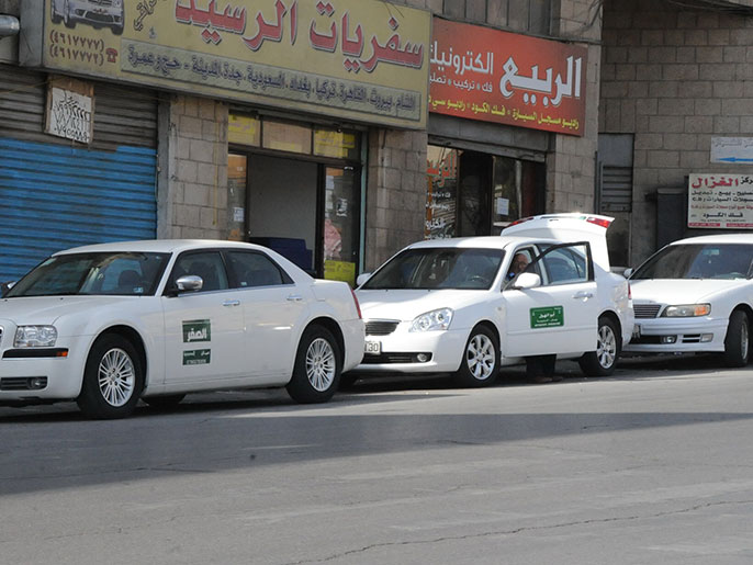 ‪سيارات أجرة أردنية تعمل على خط سوريا تنتظر مسافرين بوسط عمان‬ (الجزيرة)