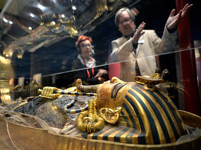 epa03874226 Visitors observe the sarcophagus of pharao Tutankhamun at a media presentation at the exposition "Toutankhamon, son tombeau et ses tresors" ("Tutankhamun, his tomb and his treasures") in Geneva, Switzerland, 19 September 2013. The exposition has already been seen by over 4 million people around the world. The exposition will be opened from 20 September 2013 until 12 January 2014. EPA/MARTIAL TREZZINI