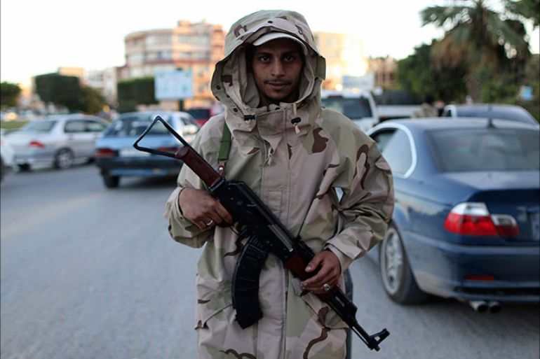 A member of the Libyan army stands guard along a street following yesterday's clashes in Benghazi November 26, 2013. Libyan troops struggling to establish control across the country clashed with militants in the eastern city of Benghazi