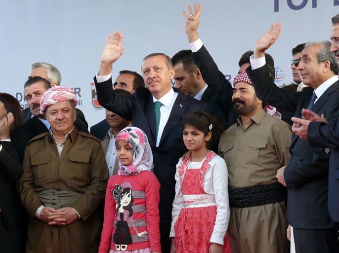 Turkish Prime Minister Recep Tayyip Erdogan (C), Iraqi Kurdish leader Massud Barzani (2nd L) and Kurdish singer Sivan Perwer (3rd R) appear on stage on November 16, 2013 in the southeastern Turkish city of Diyarbakir. Turkey's Prime Minister welcomed the leader of Iraq's autonomous north to his country's own Kurdish-dominated territory for the first time on November 16, in a visit designed to kickstart a stalled peace process. Barzani has visited the capital of Ankara many times but the November 16 meeting was described by Erdogan as "historic" and a "crowning moment" in overcoming a three-decade conflict with the banned Kurdistan Workers' Party (PKK). AFP