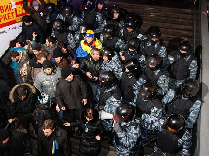 Protesters are pushed by riot police from Independence Square in Kiev, November 30, 2013. Riot police in the Ukrainian capital Kiev used batons and stun grenades to disperse hundreds of pro-Europe protesters from the city's main Independence Square early on Saturday, witnesses said. Police moved in on protesters who were still camped on the square following b