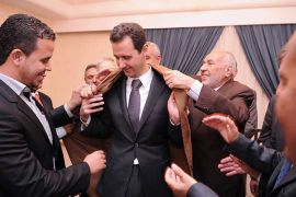 A picture uploaded on the official page of the Syrian Presidency on the internet social network site, Facebook on November 6, 2013 shows Syrian President Bashar al-Assad being offered a present by members of a pro Syrian regime Algerian delegation in Damascus, Syria. Assad made a comparison between the war in Syria against what he called "terrorists" and the war in Algeria in the 90's. AFP PHOTO / FACEBOOK