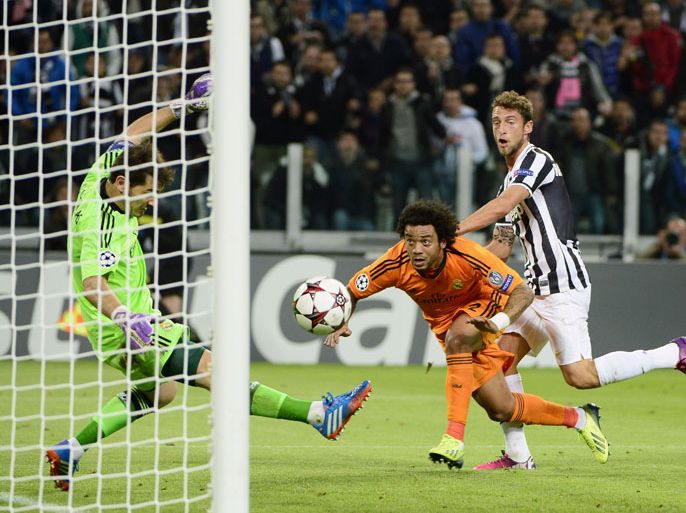 Real Madrid's goalkeeper Iker Casillas (L) saves a goal in front of Real Madrid's Brazilian defender Marcelo and Juventus midfielder Claudio Marchisio (R) on November 5, 2013 during a UEFA Champions League Group B football match at the Juventus stadium in Turin. AFP PHOTO / OLIVIER MORIN