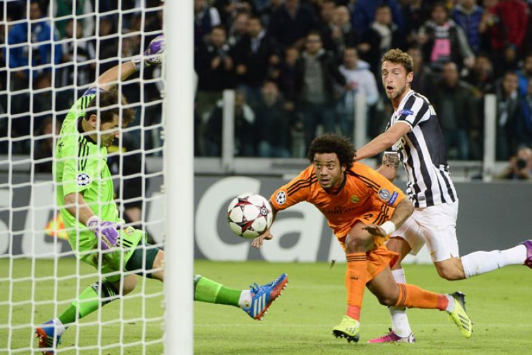 Real Madrid's goalkeeper Iker Casillas (L) saves a goal in front of Real Madrid's Brazilian defender Marcelo and Juventus midfielder Claudio Marchisio (R) on November 5, 2013 during a UEFA Champions League Group B football match at the Juventus stadium in Turin. AFP PHOTO / OLIVIER MORIN