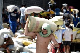 NC023 - Tacloban, -, PHILIPPINES : Residents loot water damaged sacks of rice from a rice warehouse in Tacloban in the eastern Philippine island of Leyte on November 11, 2013. The United States, Australia and the United Nations mobilised emergency aid to the Philippines as the scale of the devastation unleashed by Super Typhoon Haiyan emerged on November 11. AFP PHOTO / NOEL CELIS
