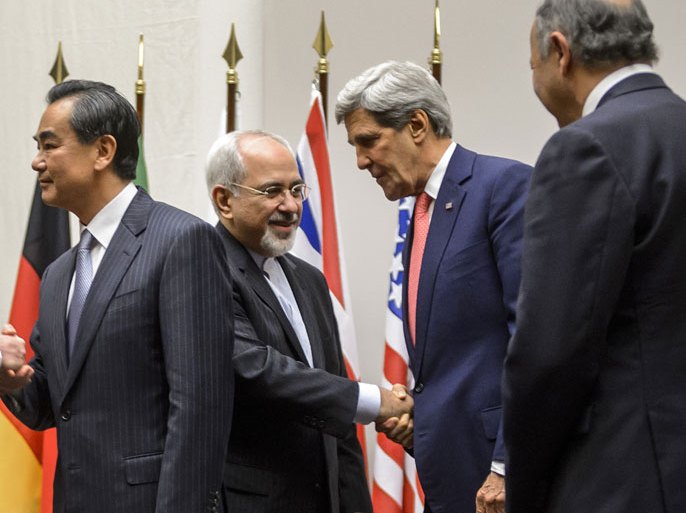 TOPSHOTS-Iranian Foreign Minister Mohammad Javad Zarif (2nd L) shakes hands with US Secretary of State John Kerry next to Chinese Foreign Minister Wang Yi (far L) and French Foreign Minister Laurent Fabius (far R) after a statement on early November 24, 2013 in Geneva. World powers on November 24 agreed a landmark deal with Iran halting parts of its nuclear programme in what US President Barack Obama called "an important first step". According to details of the accord agreed in Geneva provided by the White House, Iran has committed to halt uranium enrichment above purities of five percent. AFP PHOTO / FABRICE COFFRINI