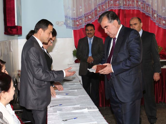 YK384 - Dushanbe, -, TAJIKISTAN : Tajikistan's President Emomali Rakhmon (R) shows identification papers as he votes at a polling station in Dushanbe, on November 6, 2013. Voters in Tajikistan, the poorest state in the former USSR, were set today to hand President Emomali Rakhmon an easy victory for a fourth term at the helm of his country bordering Afghanistan. AFP PHOTO / STR