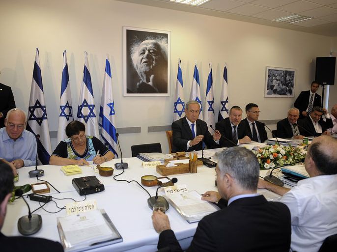 SDE BOKER, -, ISRAEL : Israeli Prime Minister Benjamin Netanyahu (C) sits in front of a portrait of the first Israeli prime minister David Ben Gurion as he looks on during a cabinet meeting in the southern Israeli kibbutz of Sde Boker, in the Negev Desert, on November 10, 2013. Netanyahu said that Israel would do all it could to keep world powers from striking a "bad and dangerous" deal with Iran over its nuclear programme. AFP PHOTO/DAVID BUIMOVITCH