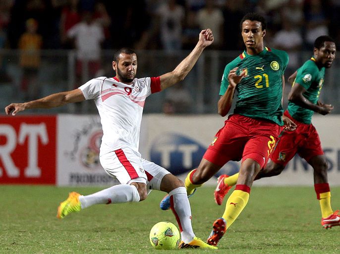 epa03908943 Tunisian player Reguid Houcin (L) vies for the ball with Cameroun's player matip Joel Job (R) during the FIFA 2014 World Cup qualifying soccer match between Tunisia and Cameroun in Rades Stadium in Tunis, Tunisia, 13 October 2013. EPA/MOHAMED MESSARA