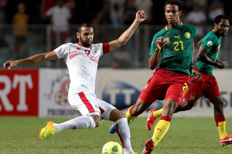 epa03908943 Tunisian player Reguid Houcin (L) vies for the ball with Cameroun's player matip Joel Job (R) during the FIFA 2014 World Cup qualifying soccer match between Tunisia and Cameroun in Rades Stadium in Tunis, Tunisia, 13 October 2013. EPA/MOHAMED MESSARA