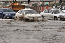 Cars drive through a flooded street in northern Riyadh, on November 17, 2013, after heavy rains fell overnight in the Saudi capital
