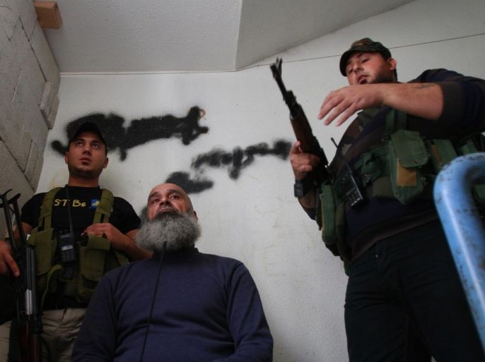 Sunni Muslim fighters stand with their weapons inside a building in Tripoli, northern Lebanon, November 30, 2013. REUTERS/Omar Ibrahim