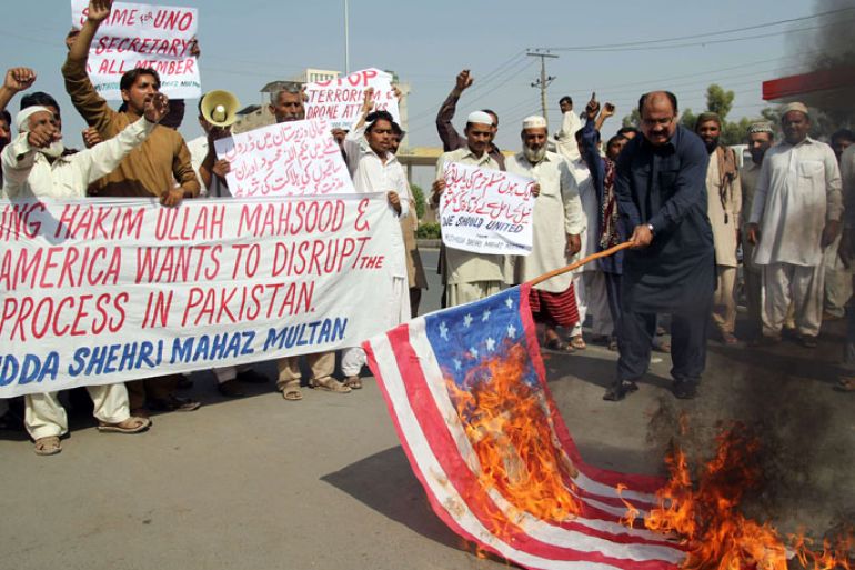AQ080 - Multan, -, PAKISTAN : A Pakistani protester from United Citizen Action (UCA) holds a burning US flag as others shout anti-US slogans during a protest against the killing of Taliban leader Hakimullah Mehsud in a US drone attack in Pakistani tribal region, in Multan on November 2, 2013. The Pakistani Taliban's supreme ruling council met on November 2, to choose a new leader after a US drone strike killed Hakimullah Mehsud, a decision seen as critical to the fate of peace talks with the government. Mehsud, who had a 5 million dollar US government bounty on him, was buried late November 1 after being killed along with four associates when a drone targeted his car in a compound in North Waziristan tribal district. AFP PHOTO / S.S MIRZA