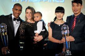 Asian Football Confederation (AFC) Player of the Year's winner Zheng Zhi from Guangzhou Evergrande (R) and his team mate Luiz Guilherme Da Conceicao Silva (L), winner of the AFC Foreign player of the Year's award, pose with their trophies and family members at a hotel in Kuala Lumpur on November 26, 2013. AFP PHOTO / MOHD RASFAN