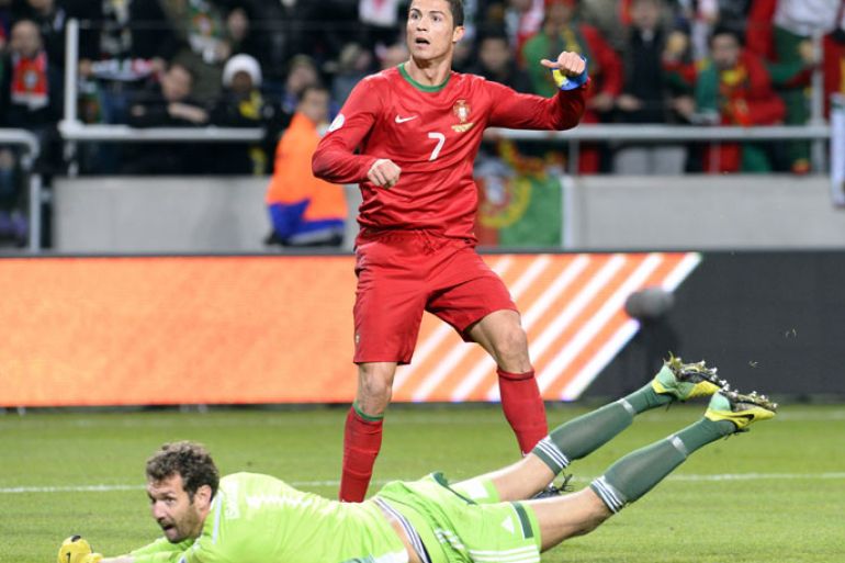 Portugal's forward Cristiano Ronaldo (up) scores 3-2 past Sweden's goalkeeper Andreas Isaksson at the Friends Arena in Solna, near Stockholm on November 19, 2013 during the FIFA 2014 World Cup playoff football match Sweden vs Portugal. AFP PHOTO/ JONATHAN NACKSTRAND