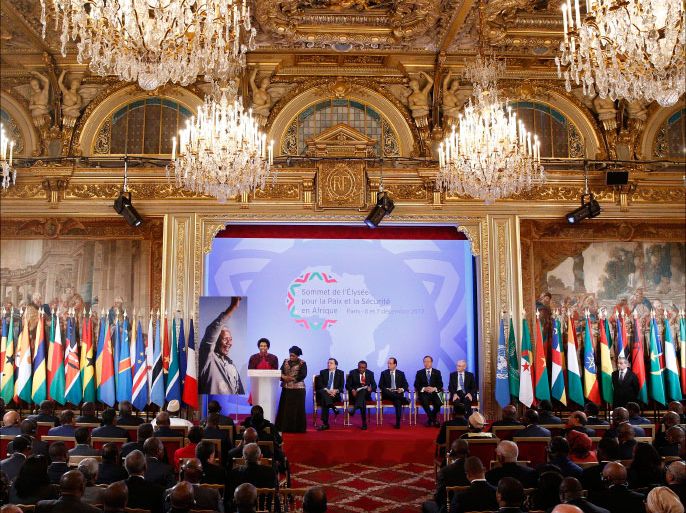 French President Francois Hollande and attendees stand next to a portrait of late South African President Nelson Mandela during the opening of the Elysee Summit for Peace and Security in Africa at the Elysee Palace, in Paris, December 6, 2013. Forty-two representatives, including presidents and heads of government take part in the two-day summit. REUTERS/Yoan Valat/Pool (FRANCE - Tags: POLITICS)
