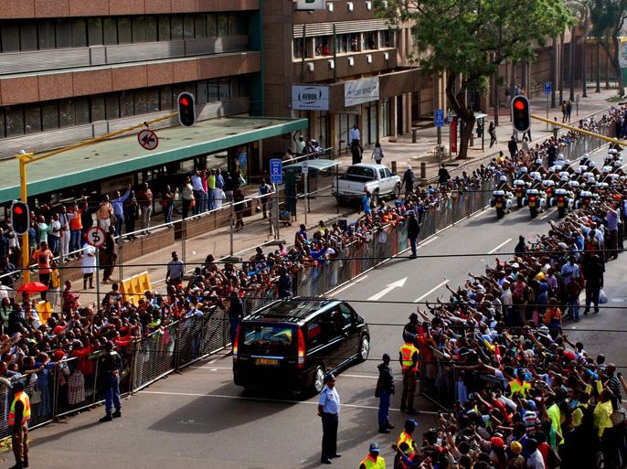 Johannesburg, -, South Africa : This handout photo taken and released by the Government Communication and Information System (GCIS) shows people celebrating as the funeral cortege of South African former president Nelson Mandela drives on its way to the Union Buildings for the lying in state on December 12, 2013 in Pretoria. Mandela, the revered icon of the anti-apartheid struggle in South Africa and one of the towering political figures of the 20th century, died in Johannesburg on December 5 at age 95. AFP PHOTO / KATLHOLO MAIFADI