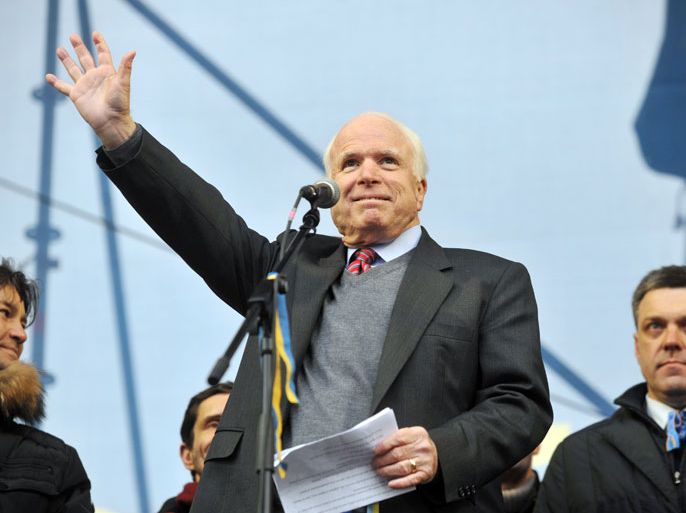 US Senator John McCain waves to protestors during a mass rally of the opposition Independence Square in Kiev on December 15, 2013. McCain told more than 200,000 EU supporters rallying in Kiev on Sunday that Washington backed their desire for European integration. "To all Ukraine, America stands with you," he called out to the cheering crowd. "The free world is with you, America is with you, I am with you... Ukraine will make Europe better and Europe will make Ukraine better." AFP PHOTO/ GENYA SAVILOV