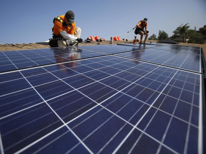 Vivint Solar technicians install solar panels on the roof of a house in Mission Viejo, California, in this October 25, 2013 file photo. REUTERS/Mario Anzuoni/Files