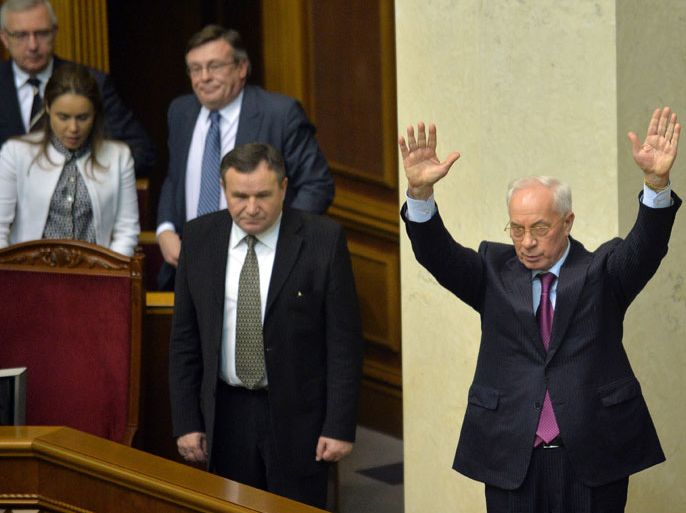SUP1203 - Kiev, -, UKRAINE : Ukraine's Prime Miister Mykola Azarov greets deputies of the majority after a for his resignation at the parliament in Kiev on December 3, 2013. Ukraine's parliament on Tuesday rejected an opposition no-confidence motion in Prime Minister Mykola Azarov's government after the ruling party abstained from the vote. The measure gathered 186 out of the required 226 votes in the Verkhovna Rada parliament with support from the three main opposition parties that sought Azarov's resignation over Ukraine's refusal to sign a historic EU trade and political pact. . AFP PHOTO/ SERGEI SUPINSKY