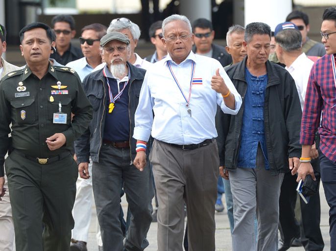 -, THAILAND : Thai protest leader Suthep Thaugsuban (C) walks with his staff prior to meeting with Thai military chiefs at the Thai Armed Forces headquarters in Bangkok on December 14, 2013. Bangkok has been shaken by more than a month of mass opposition demonstrations aimed at ousting Prime Minister Yingluck Shinawatra and ridding the kingdom of the influence of her older brother, deposed former leader Thaksin. AFP PHOTO / PORNCHAI KITTIWONGSAKUL