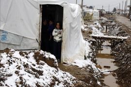 Syrian refugee children stand at the entrance of their make-shift house during a storm in the Dalhamiyyeh camp for Syrian refugees in the Lebanese Bekaa valley, on December 11, 2013. Thousands of Syria
