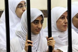 A photo made available on 28 November 2013 shows female Islamist demonstrators standing behind bars during a trial session at a court in Alexandria, Egypt, 27 November 2013. Media reports state an Egyptian court on 27 November handed down 11-year sentences to 21 female Islamist demonstrators, who were arrested after an early morning demonstration in the coastal city. Seven of the defendants are minors and will be sent to a juvenile home, while the remainders were jailed. EPA/HAZEM JUDEH/ALMASRY ALYOUM EGYPT OUT