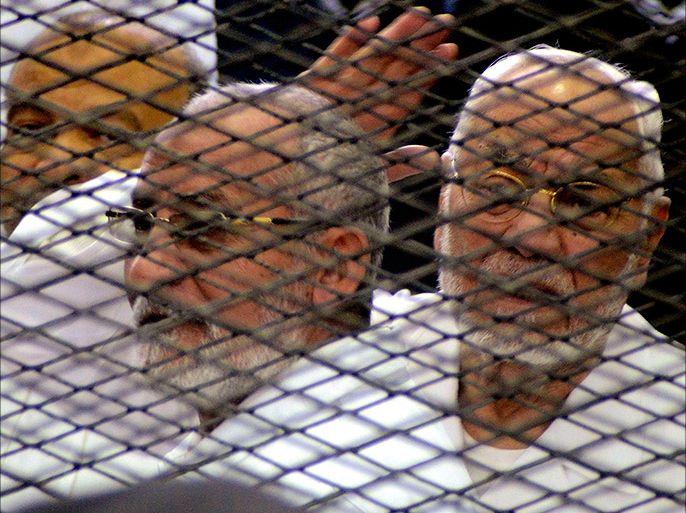 epa03986526 Leader of Egypt's Muslim Brotherhood, Mohammed Badie (C), stands behind bars along with senior leaders Saad Katatni (L) and Mahdi Akef (R), during their trial, in Cairo, Egypt, 11 December 2013. The trial of top Muslim Brotherhood leaders charged with inciting deadly violence against anti-Islamist protesters opened in Egypt on 11 December. The 30 defendants include Brotherhood chief Mohammed Badie and his two deputies, Khayrat al-Shater and Mohammed Bayoumi. EPA/ALY ELMALKY/ ALMASRY ALYOUM EGYPT OUT