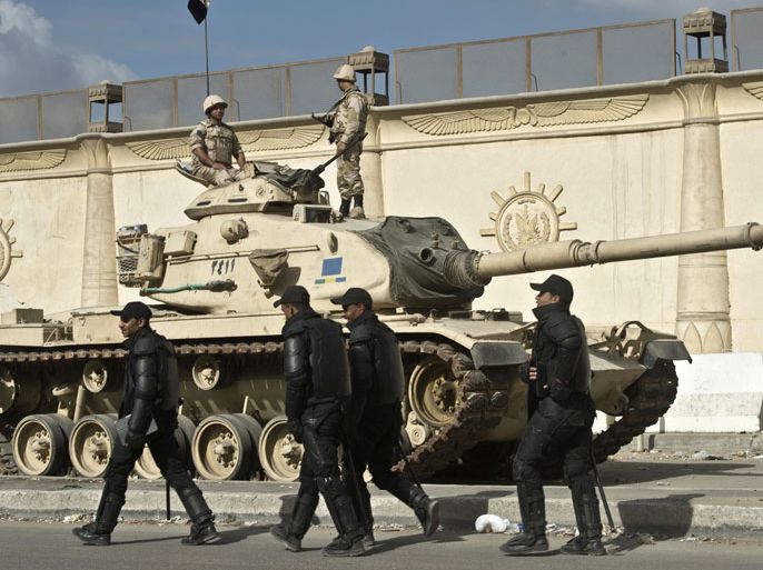 Egyptian army tanks are positioned outside Turah prison during the trial at the police institute in Cairo on December 9, 2013, of Muslim Brotherhood chief Mohamed Badie and other senior figures from the group on charges of "incitement to murder" in the Egyptian capital's neighbourhood of Bahr al-Aazam, after deadly clashes erupted there in July. AFP PHOTO / KHALED DESOUKI