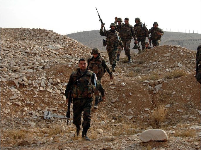 epa03955801 Syrian army soldiers patrol the area of Mehin town, eastern Homs province, Syria, 18 November 2013. Media reports state that the Syrian army had seized weapons warehouses from rebels in the Mehin town. EPA/STR