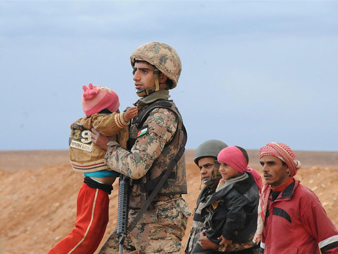 جنديان أردنيان يقدمان مساعدة للاجئين سوريين يعبرون الحدود (الجزيرة-أرشيف)