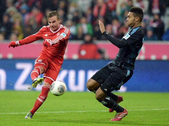 (L-R) Bayern Munich's midfielder Mario Goetze scores the socond goal against Hamburg's defender Jonathan Tah during the German first division Bundesliga football match between FC Bayern Munich and Hamburger SV on December 14, 2013 at the stadium in Munich, southern Germany