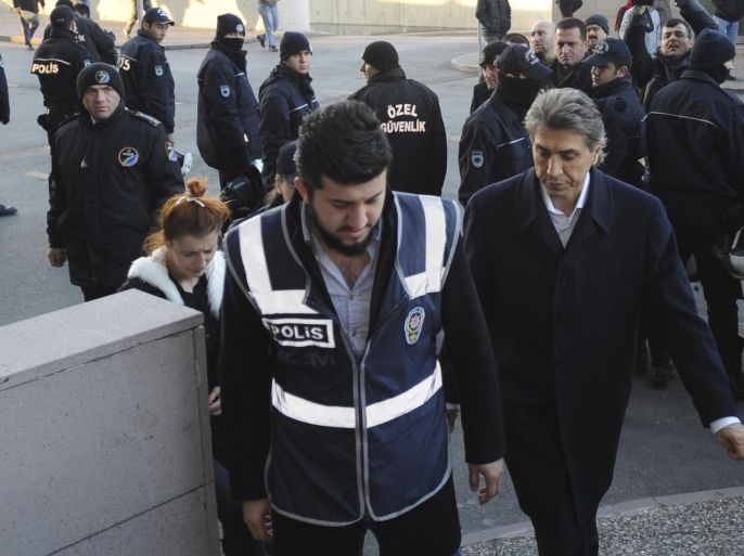 Mustafa Demir (R), mayor of Istanbul's Fatih district, is escorted by a police officer as he arrives at a courthouse in Istanbul December 20, 2013. Turkish police arrested eight people in connection with allegations of official corruption and bribery, a newspaper said on Friday, in an investigation Prime Minister Tayyip Erdogan has called a "dirty operation" aimed at undermining his rule. Among those remanded in custody was the brother of the mayor of Istanbul's historic Fatih district, Hurriyet daily said. It was not clear who else had been arrested. Mayor of Fatih, Mustafa Demir, was detained this week, and on Friday was in court to hear if he would be arrested or freed, Dogan News Agency said. REUTERS/Stringer (TURKEY - Tags: POLITICS CRIME LAW)