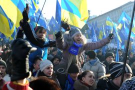 Supporters of Ukrainian president Viktor Yanukovych wave Ukrainian flags and shout slogans as they take part in a mass rally on European Square in Kiev on December 14, 2013. Ukraine's capital braced for a tense weekend on December 14 as supporters of President Viktor Yanukovych prepared to mount a massive rally right next to the camp of pro-EU protesters who demand his resignation. AFP PHOTO/ VIKTOR DRACHEV