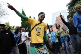 AFRICA : A man wearing a yellow t-shirt of the South African ANC ruling party grieves with other people on December 6, 2013 outside the house of former South African President Nelson Mandela in Johannesburg. Mandela, the revered icon of the anti-apartheid struggle in South Africa and one of the towering political figures of the 20th century, has died aged 95. Mandela, who was elected South Africa's first black president after spending nearly three decades in prison, had been receiving treatment for a lung infection at his Johannesburg home since September, after three months in hospital in a critical state. AFP PHOTO / STEPHANE