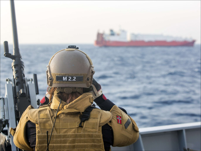 ‪أحد ضباط القوات النرويجية يراقب سفينة أخرى من السفن المكلفة ضمن العملية بالمتوسط‬ (الفرنسية)