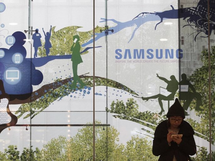 A woman uses her smart phone at the Samsung Electronics Co. showroom of its headquarters in Seoul, South Korea, Thursday, Dec. 12, 2013. A Seoul court rejected Samsung's claim that iPhone and iPad models violated three of its patents, another setback for the South Korean electronics giant in a global battle with Apple over rights to technologies that power smartphones and tablets.(AP Photo/Ahn Young-joon)