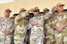 A handout picture released by the Egyptian Ministry of Defence shows Egypt's military chief Abdel Fattah al-Sisi (C) gesturing as he stands alongside army officers during the graduation ceremony of a new batch of non-commissioned officers, in Cairo, on December 26, 2013. The military-installed government's listing of Egypt's Muslim Brotherhood as a terrorist group signals determination to uproot its vast grass-roots network, possibly radicalising the Islamists as they go underground, analysts said. AFP PHOTO/EGYPTIAN MINISTER OF DEFENCE/HO == RESTRICTED TO EDITORIAL USE - MANDATORY CREDIT "AFP PHOTO / EGYPTIAN MINISTER OF DEFENCE" - NO MARKETING NO ADVERTISING CAMPAIGNS - DISTRIBUTED AS A SERVICE TO CLIENTS ==