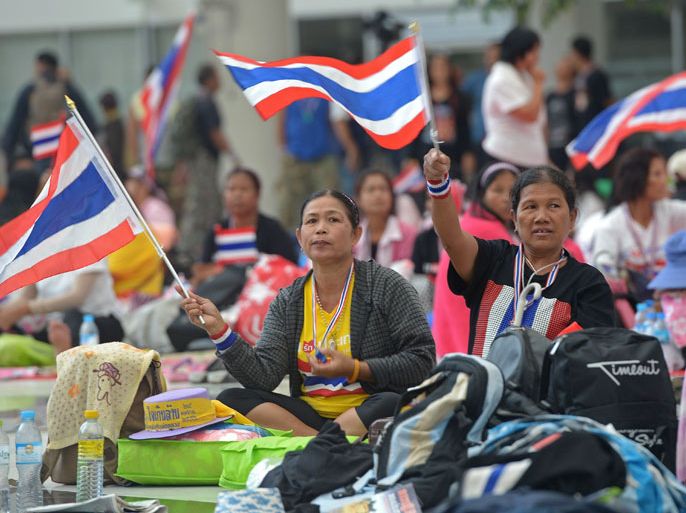 PK1180 - Bangkok, -, THAILAND : Thai anti government protesters wave national flags as they rally at Government Complex in Bangkok on December 8, 2013. The leader of mass opposition protests that have shaken the Thai capital called for a last-ditch effort to topple the government, vowing to surrender to the authorities if the action fails. AFP PHOTO / PORNCHAI KITTIWONGSAKUL
