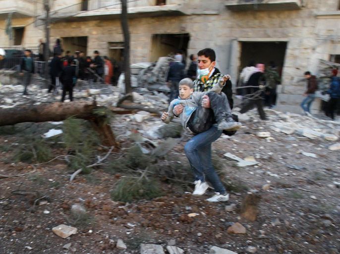 A man carries a wounded boy who survived what activists say was an air strike by forces loyal to Syrian President Bashar al-Assad in Aleppo's al-Ansari al-Sharqi neighbourhood, December 9, 2013. REUTERS/Ammar Abdullah (SYRIA - Tags: POLITICS CIVIL UNREST CONFLICT)