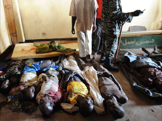 TOPSHOTSPeople stand near bodies found lying in a mosque and in its surrounding streets in the Central African capital Bangui on December 5, 2013, after overnight violence. AFP reporters counted 54 corpses in a mosque in the PK5 area of the capital and another 25 lining surrounding streets, all of them with bullet or machete wounds as the United Nations authorised French-backed military intervention in the imploding Central African Republic.