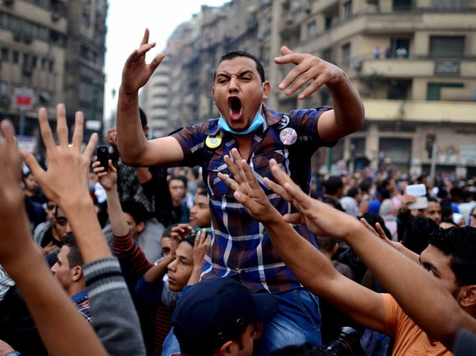 Cairo University's students backing ousted Islamist president Mohamed Morsi shout slogans during a demonstration against July's military "coup," in Tahrir square on December 1, 2013 in Cairo, Egypt. Protesters were chanting "Down with the military regime!", "People want the fall of the regime!" and "Rabaa Rabaa", an AFP reporter said, as demonstrators flashed a four-finger sign that has become associated with a government crackdown on pro-Morsi supporters in Cairo's Rabaa al-Adawiya square on August 14. AFP PHOTO/MOHAMED EL-SHAHED